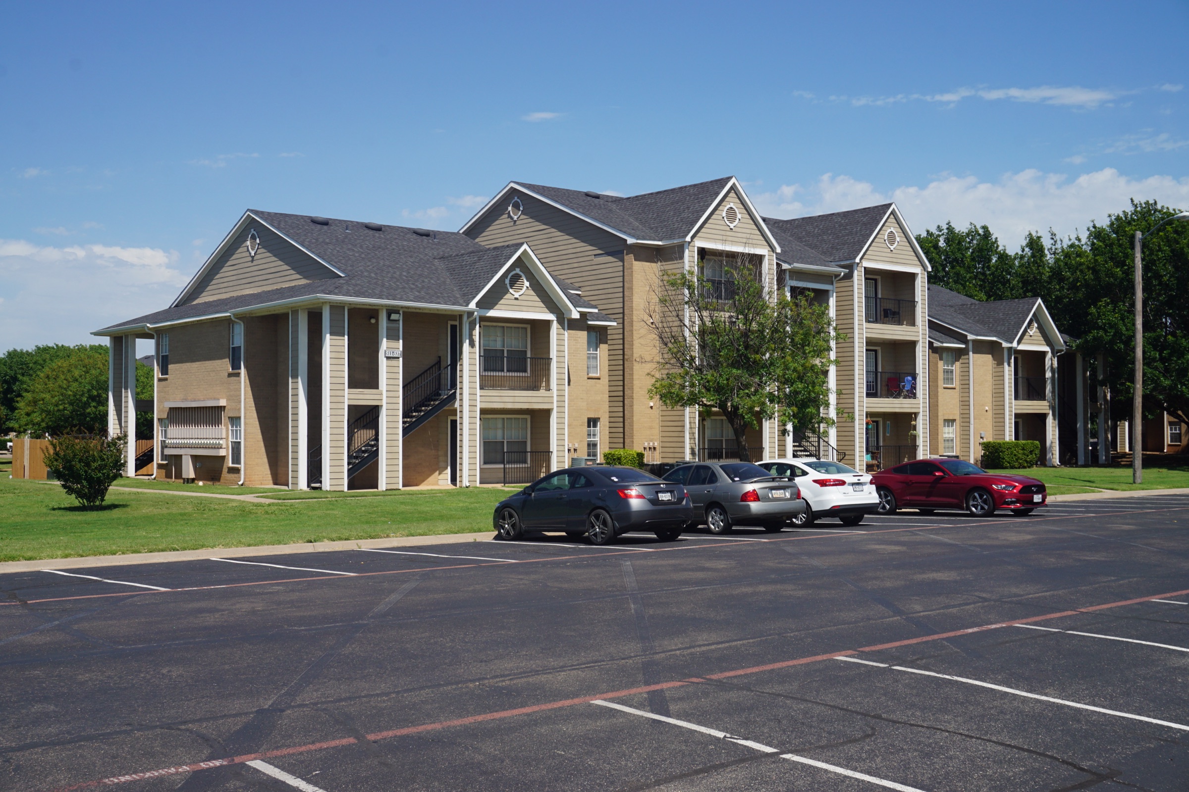 Two-story garden-style apartment buildings under a clear sky