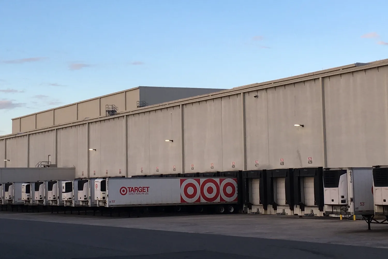 Distribution center with trailers backed into a long row of loading docks