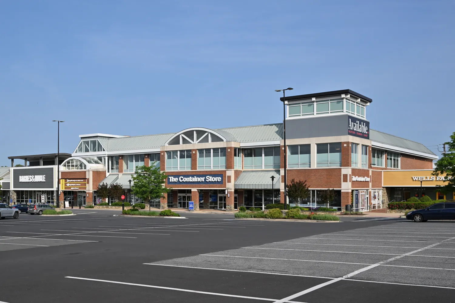 Anchored retail center with storefronts facing a large parking lot