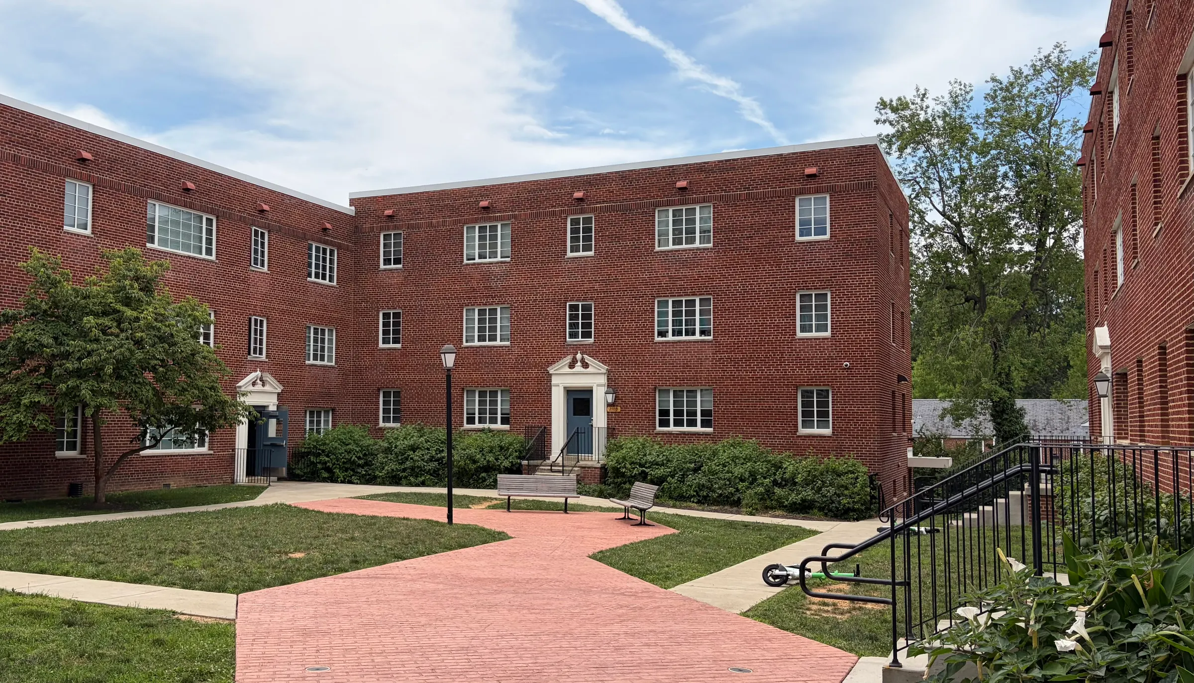 Well-kept brick apartment building with a lawn and walkway